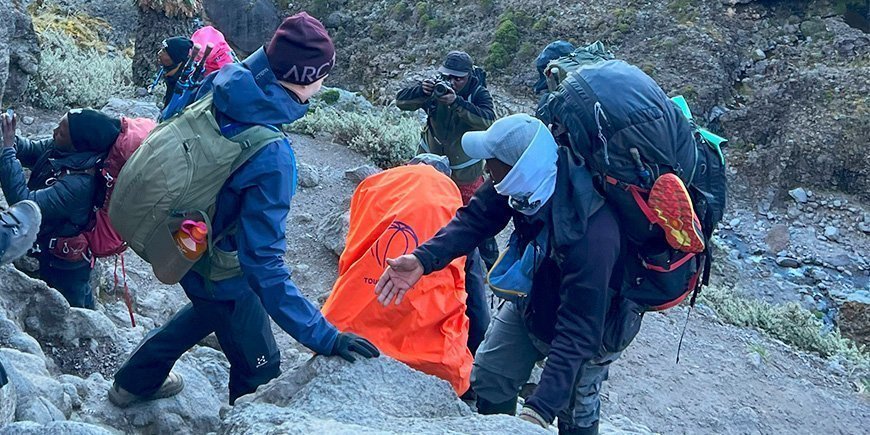 Gids helpt klimmer een handje