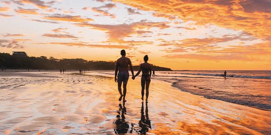 Man en vrouw lopen op Tamarindo Beach in Costa Rica